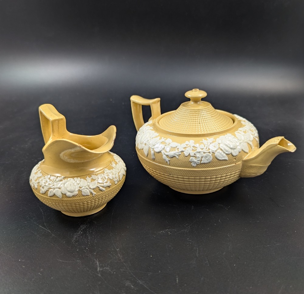 A Regency period buff stoneware teapot and matching creamer jug featuring engine-turned lattice patterning and applied white botanical reliefs. View IV