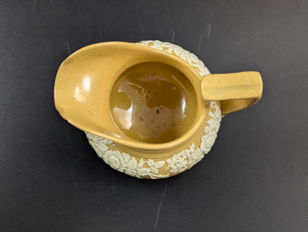 A Regency period buff stoneware teapot and matching creamer jug featuring engine-turned lattice patterning and applied white botanical reliefs. View XIV