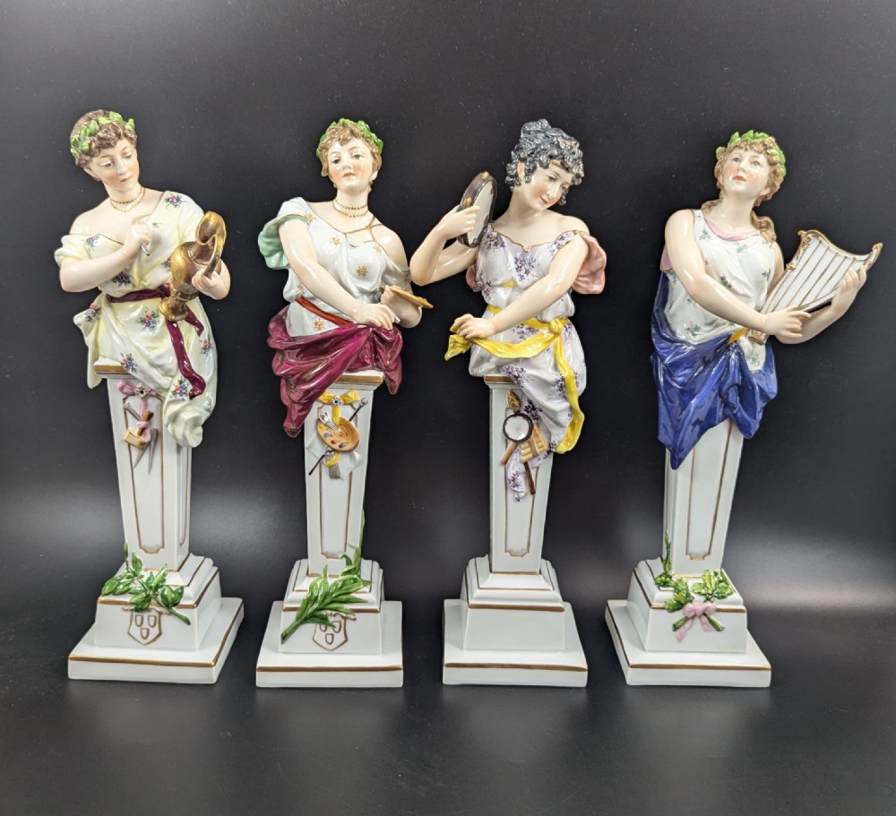 A set of four 19th-century glazed Italian porcelain figurines depicting allegorical female figures representing the arts atop gilded square pedestals.