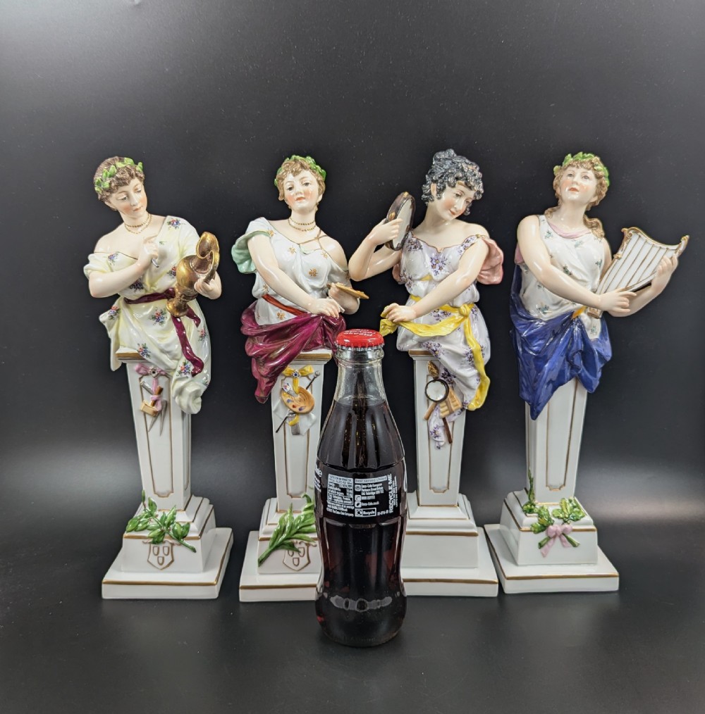 A set of four 19th-century glazed Italian porcelain figurines depicting allegorical female figures representing the arts atop gilded square pedestals. View IV
