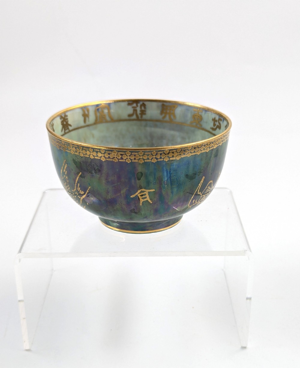 An Art Deco Wedgwood lustre bowl featuring an iridescent green glaze and gilded depictions of mythic animals and Chinese characters. View X
