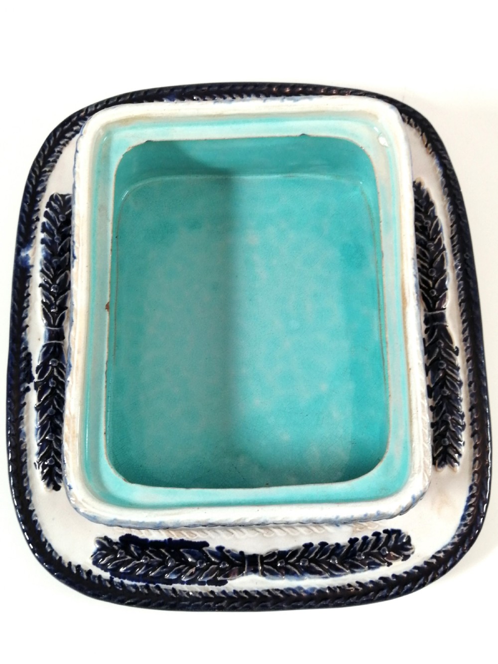 A rectangular Victorian majolica sardine box with matching undertray featuring cobalt blue fish relief decoration on an off-white lid. View X