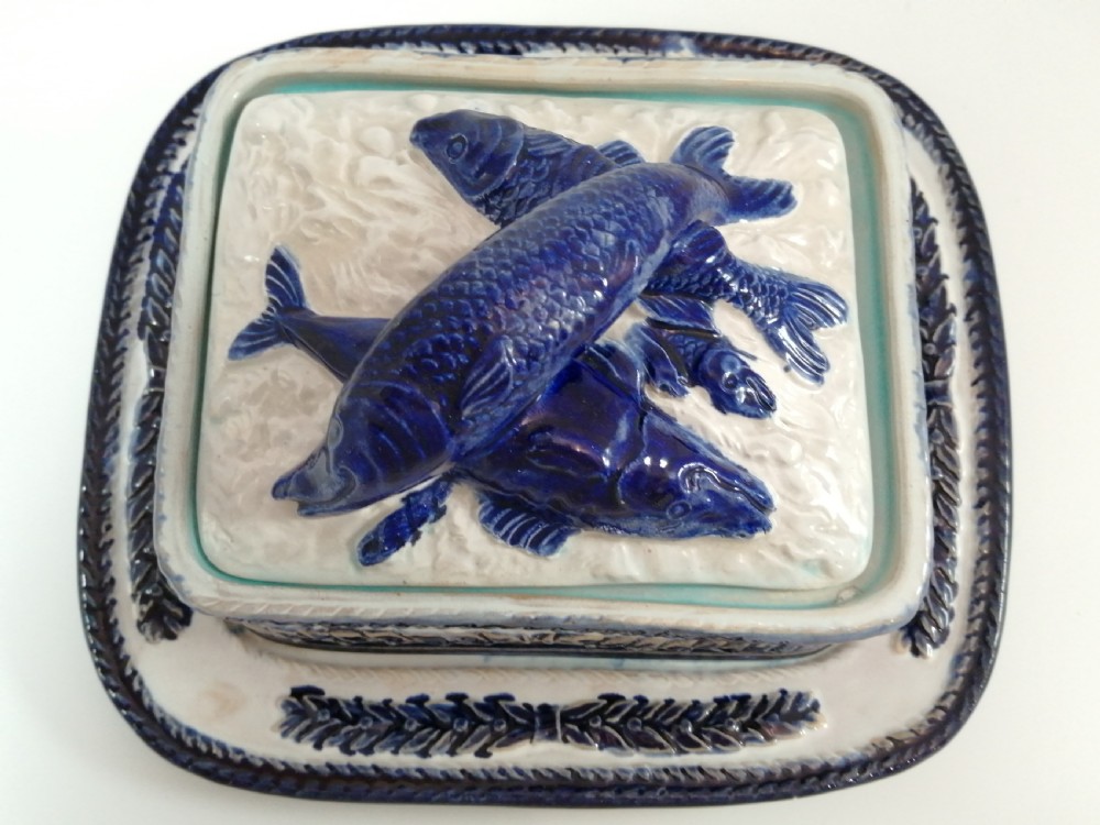 A rectangular Victorian majolica sardine box with matching undertray featuring cobalt blue fish relief decoration on an off-white lid. View XII