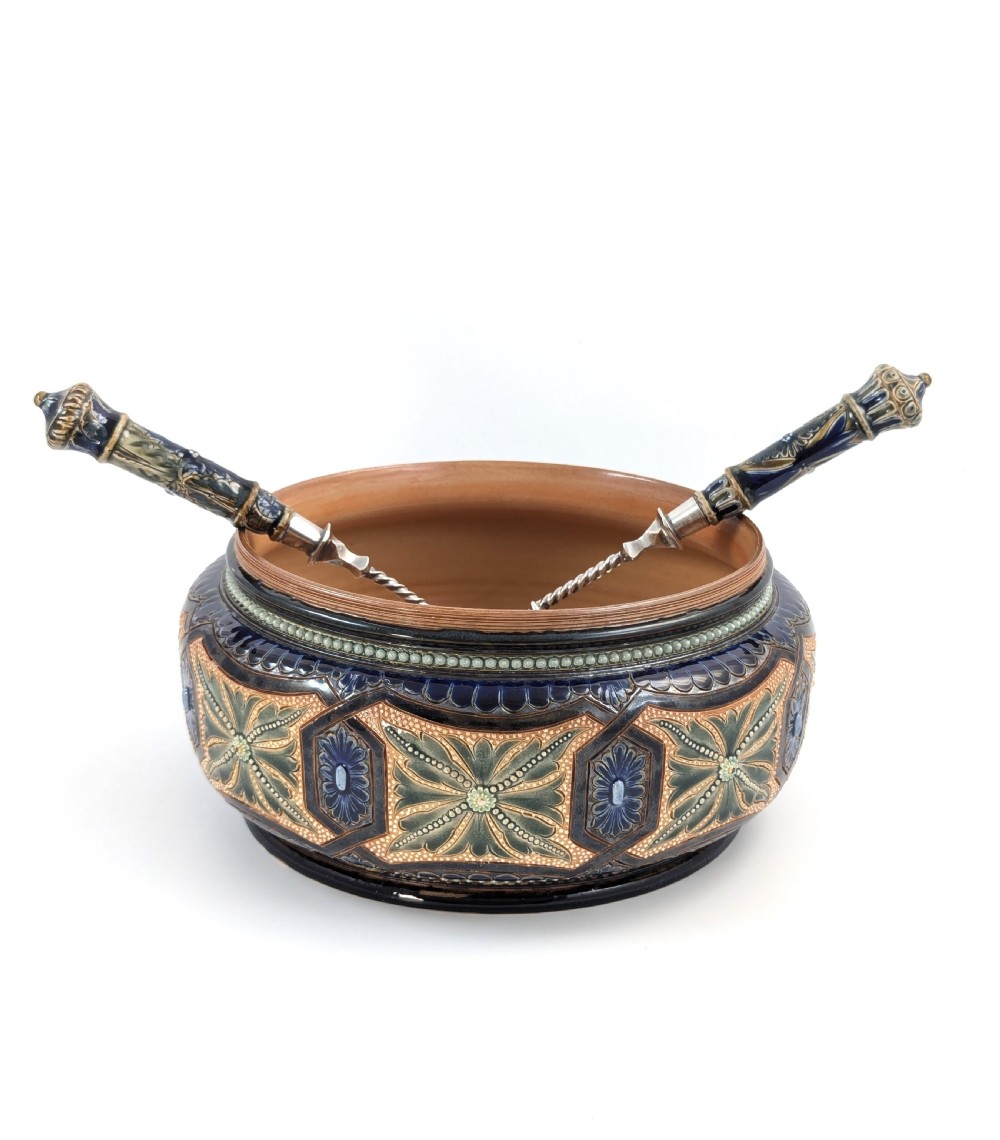 A Victorian Doulton Lambeth stoneware salad bowl decorated with cobalt blue and terracotta geometric patterns, presented with two matching ceramic-handled silver servers.