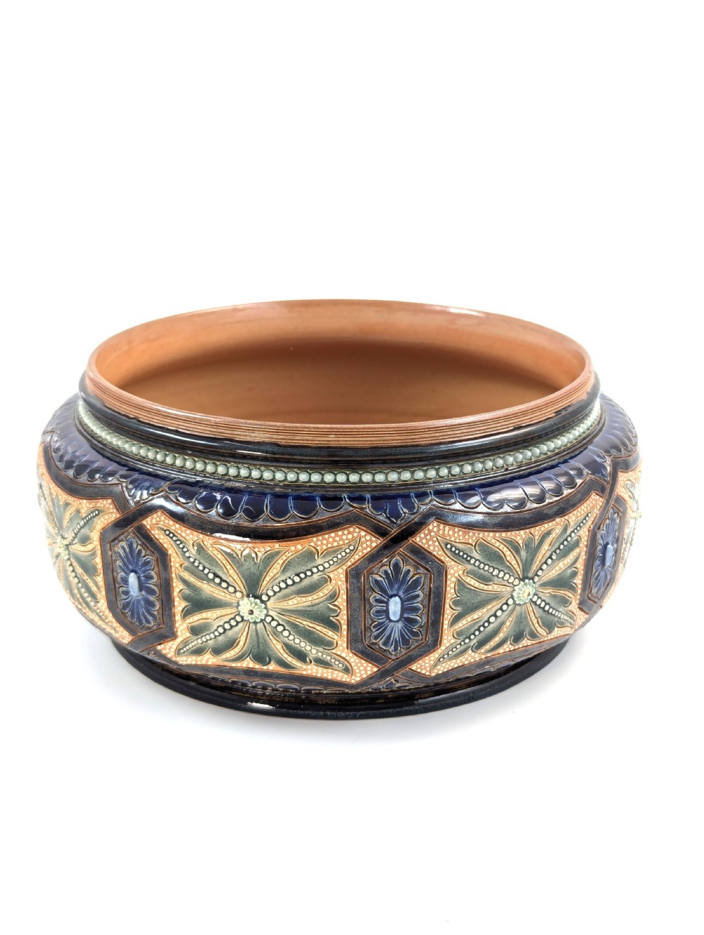 A Victorian Doulton Lambeth stoneware salad bowl decorated with cobalt blue and terracotta geometric patterns, presented with two matching ceramic-handled silver servers. View III