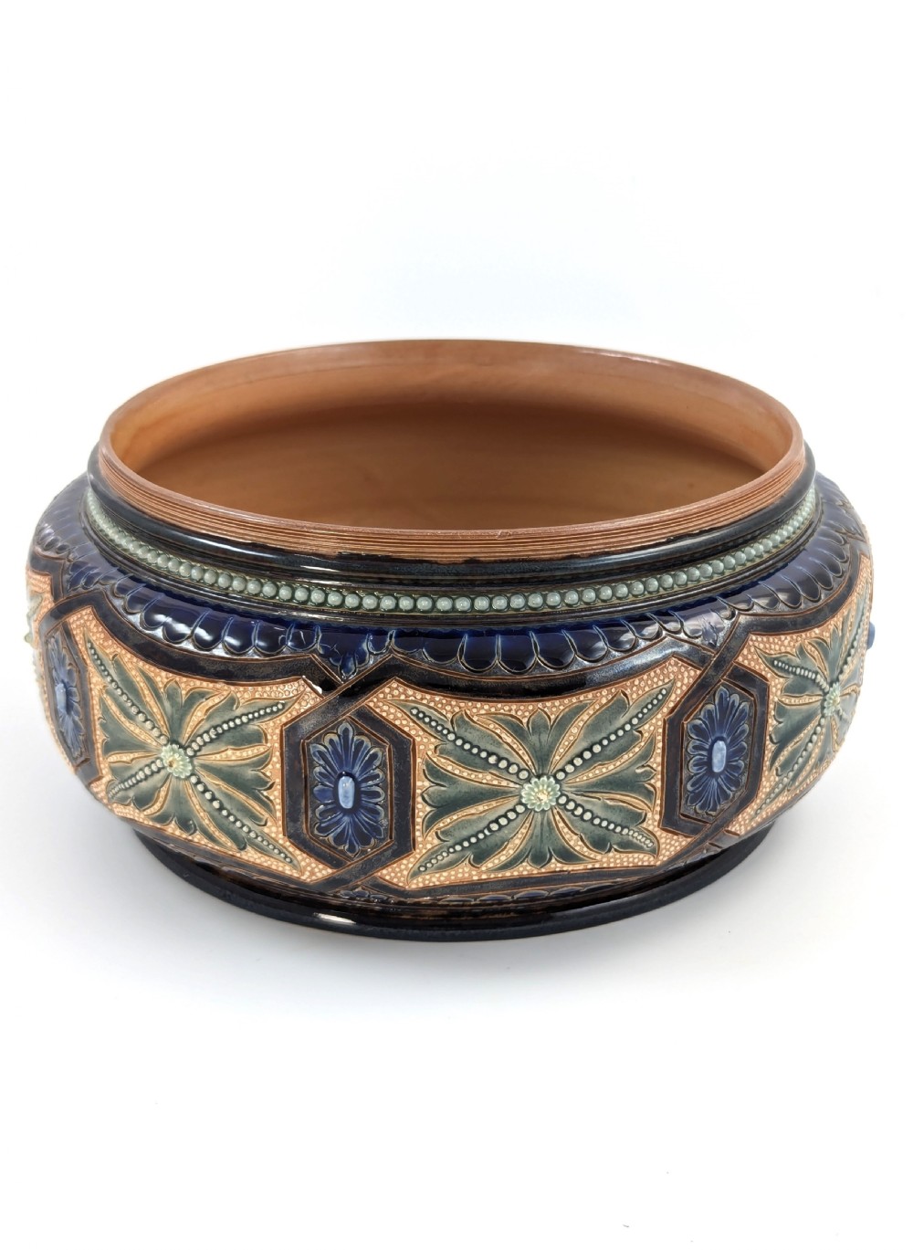A Victorian Doulton Lambeth stoneware salad bowl decorated with cobalt blue and terracotta geometric patterns, presented with two matching ceramic-handled silver servers. View VI