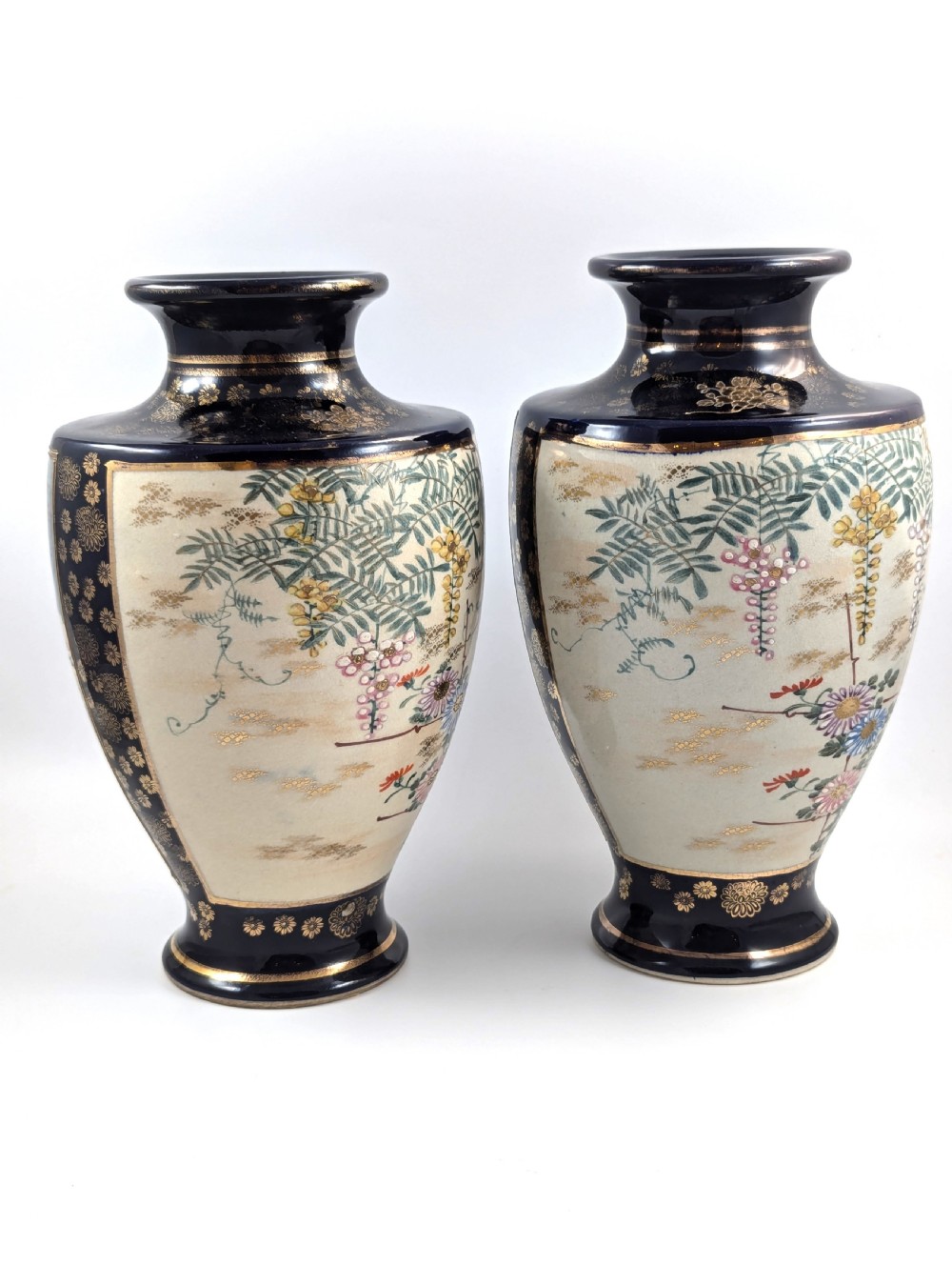 A pair of Japanese Satsuma baluster vases featuring painted figures in a snowy landscape framed by cobalt blue and gilded borders. View III