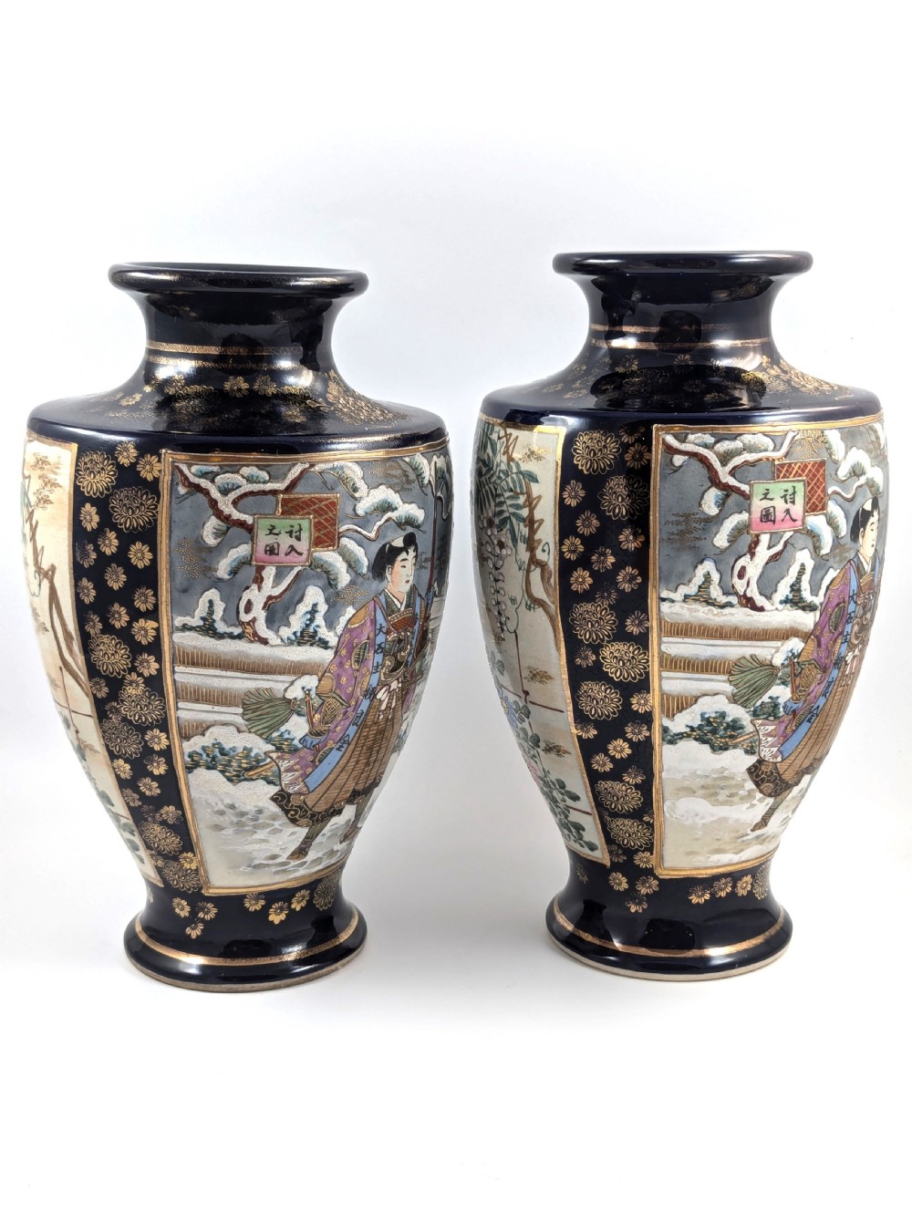 A pair of Japanese Satsuma baluster vases featuring painted figures in a snowy landscape framed by cobalt blue and gilded borders. View V