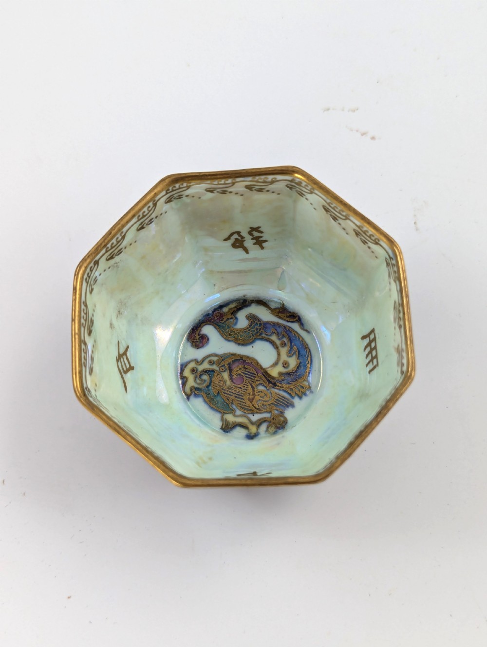 An octagonal Wedgwood Fairyland Lustre porcelain bowl decorated with gilded goldfish motifs over a mottled deep purple exterior and an iridescent pale interior. View VII
