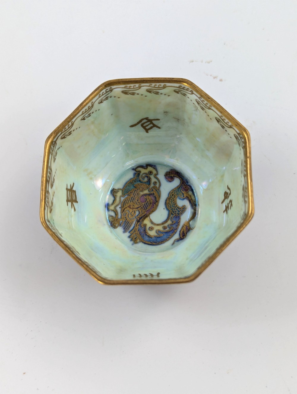 An octagonal Wedgwood Fairyland Lustre porcelain bowl decorated with gilded goldfish motifs over a mottled deep purple exterior and an iridescent pale interior. View VIII