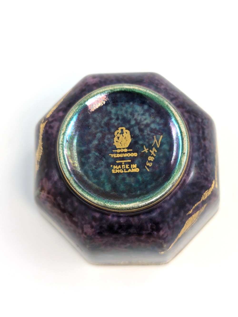 An octagonal Wedgwood Fairyland Lustre porcelain bowl decorated with gilded goldfish motifs over a mottled deep purple exterior and an iridescent pale interior. View IX
