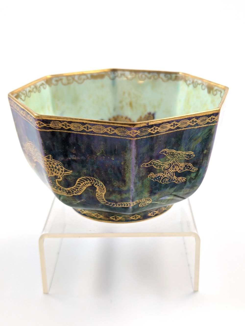 An octagonal blue iridescent porcelain bowl featuring gilded dragon motifs and geometric gold trim around the rim. View II