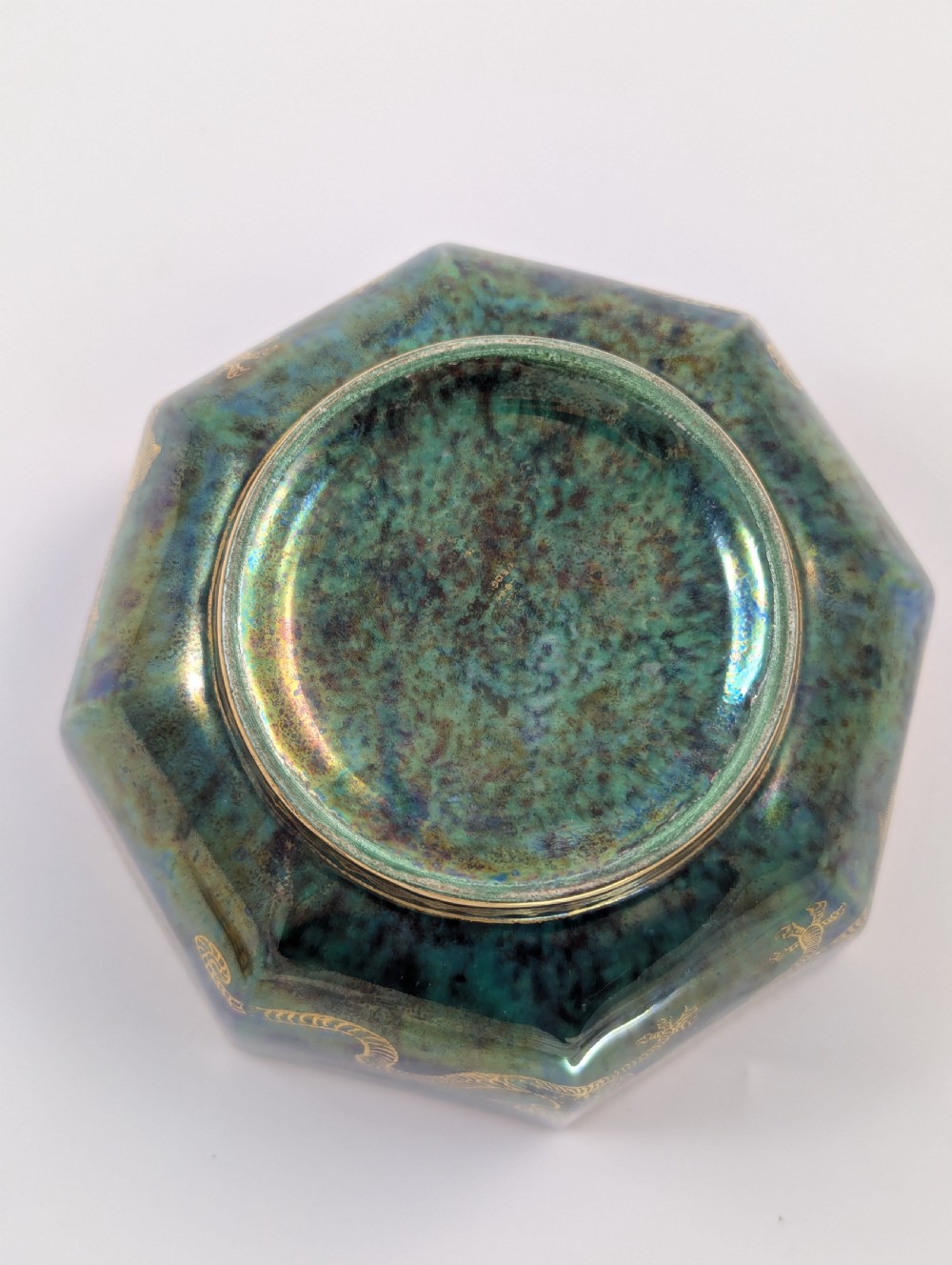 An octagonal blue iridescent porcelain bowl featuring gilded dragon motifs and geometric gold trim around the rim. View X