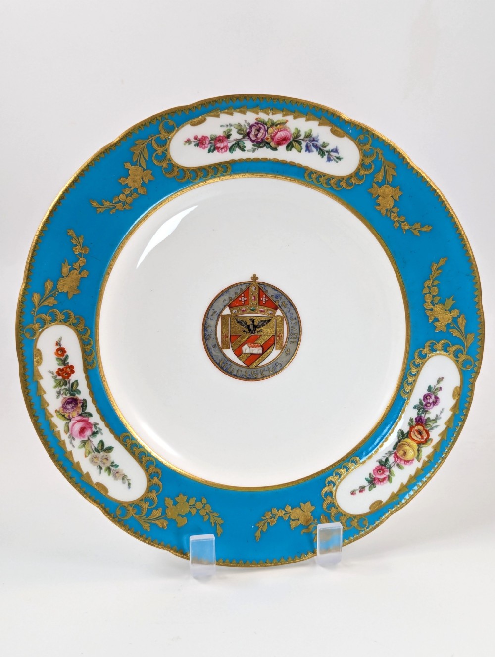 A pair of Victorian Minton porcelain cabinet plates featuring turquoise rims with gilt details, floral cartouches, and a central painted coat of arms. View II