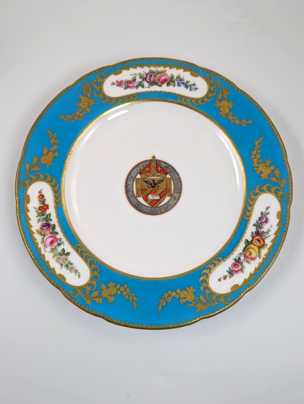 A pair of Victorian Minton porcelain cabinet plates featuring turquoise rims with gilt details, floral cartouches, and a central painted coat of arms. View VI