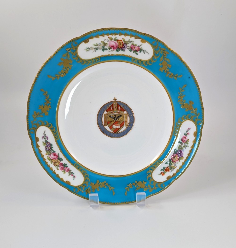 A pair of Victorian Minton porcelain cabinet plates featuring turquoise rims with gilt details, floral cartouches, and a central painted coat of arms. View VIII