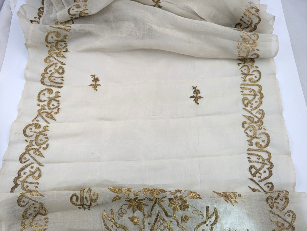 A light cream silk scarf featuring metallic gold thread hand embroidery with floral motifs, crescent symbols, and calligraphic borders. View VII