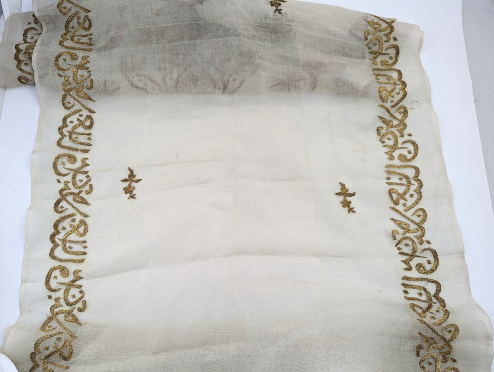 A light cream silk scarf featuring metallic gold thread hand embroidery with floral motifs, crescent symbols, and calligraphic borders. View X