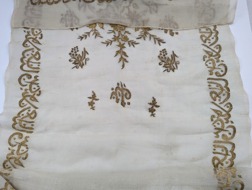 A light cream silk scarf featuring metallic gold thread hand embroidery with floral motifs, crescent symbols, and calligraphic borders. View XI