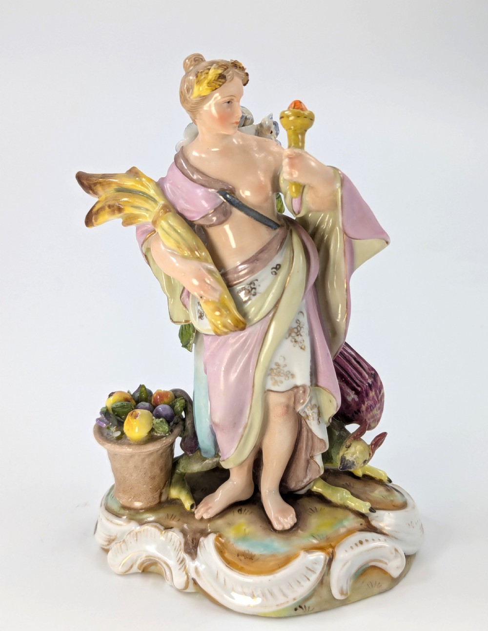 Late 19th-century German Volkstedt porcelain allegorical figurine depicting a draped female figure holding a torch and sheaf of wheat atop a gilded scroll base. View VI