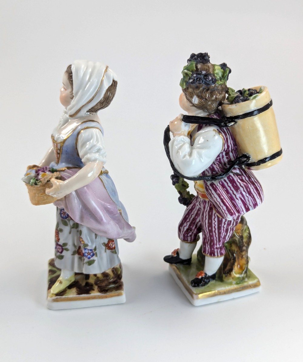 Pair of late 19th-century Helena Wolfsohn porcelain child figurines featuring hand-painted floral attire, baskets, and gilded bases. View II