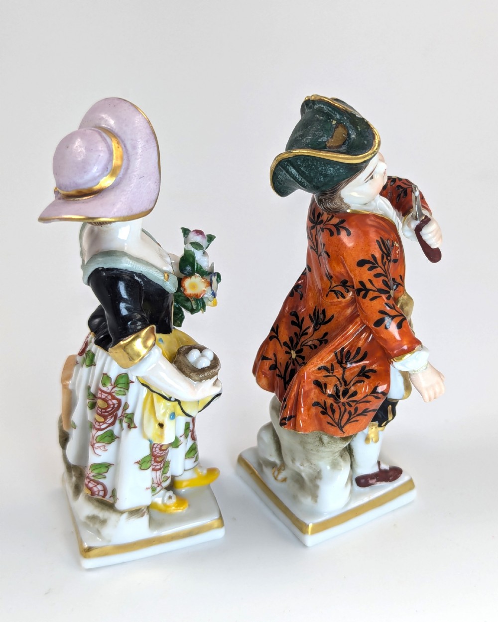 A pair of early 19th-century Chelsea-style hand-painted porcelain figurines depicting a female gardener and a male farmer with gilded accents. View IV