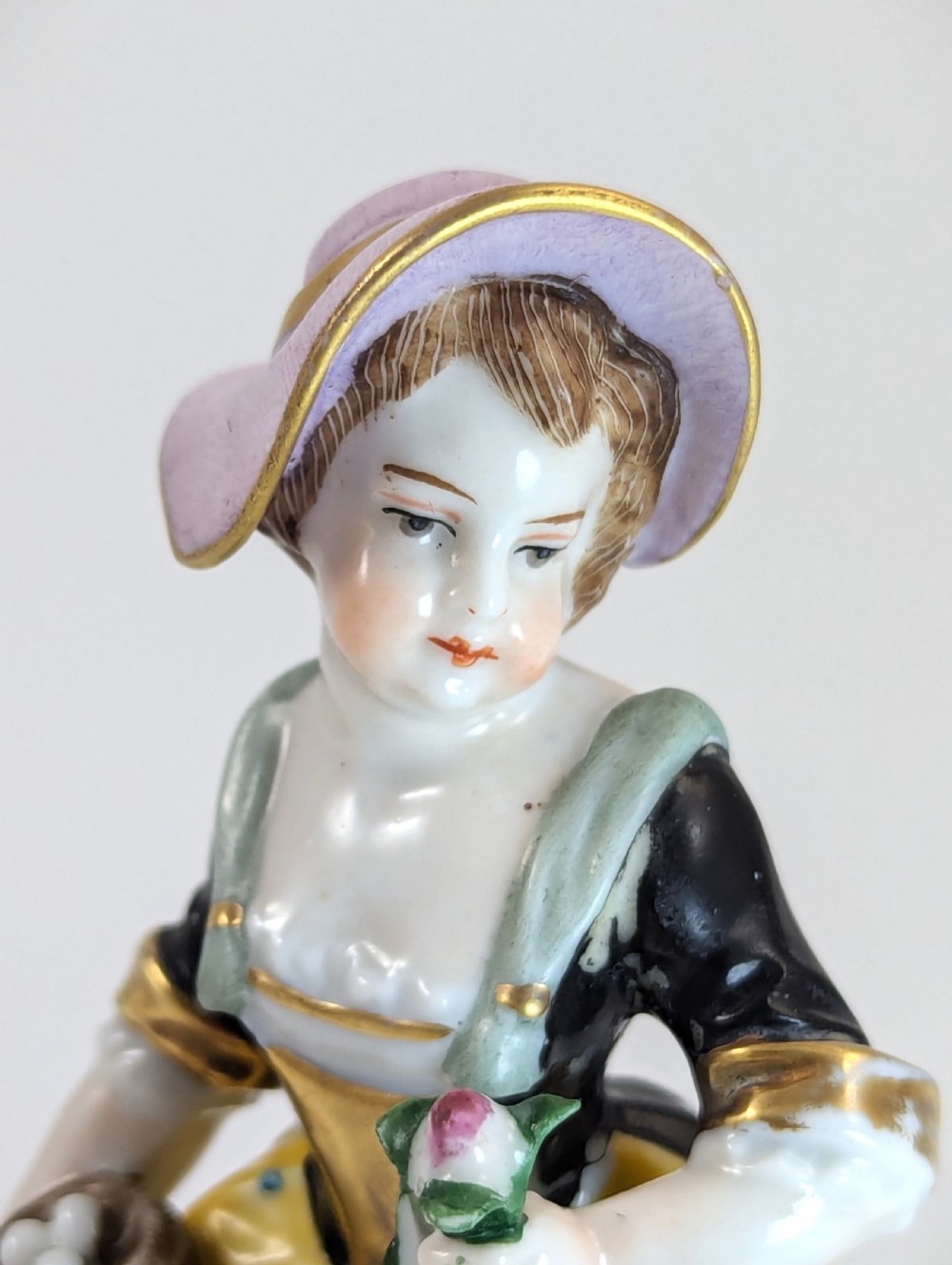 A pair of early 19th-century Chelsea-style hand-painted porcelain figurines depicting a female gardener and a male farmer with gilded accents. View IX