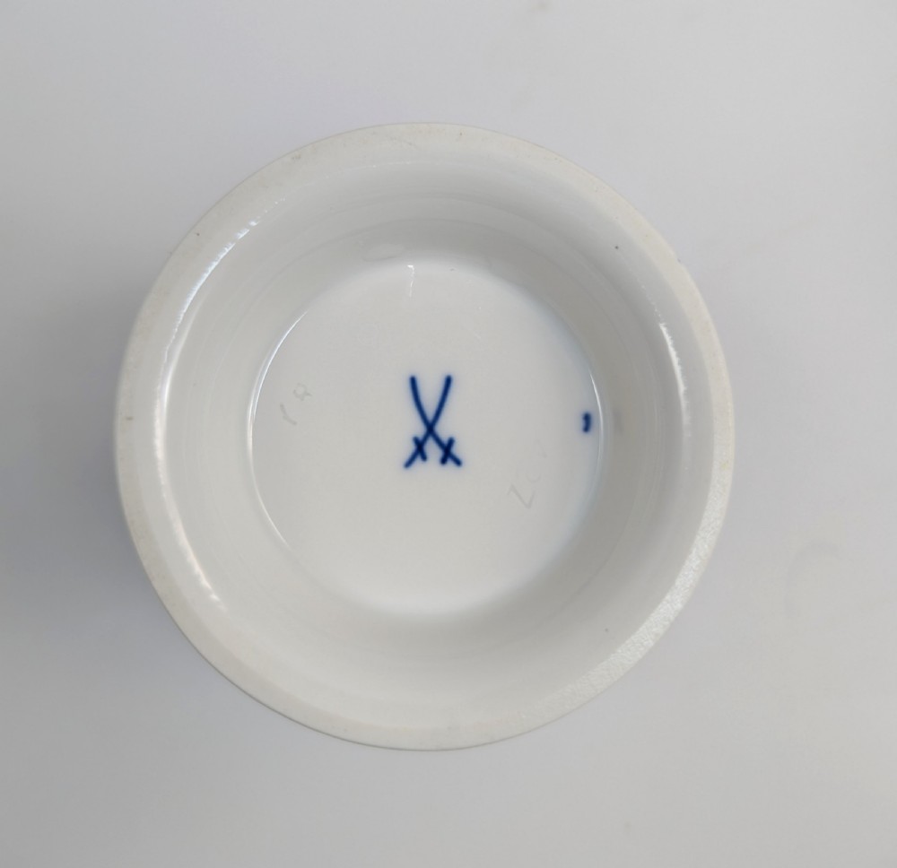 A pair of small Meissen cobalt blue porcelain vases featuring scalloped gilt rims, hand-painted floral cartouches, scroll feet, and circular white bases. View X