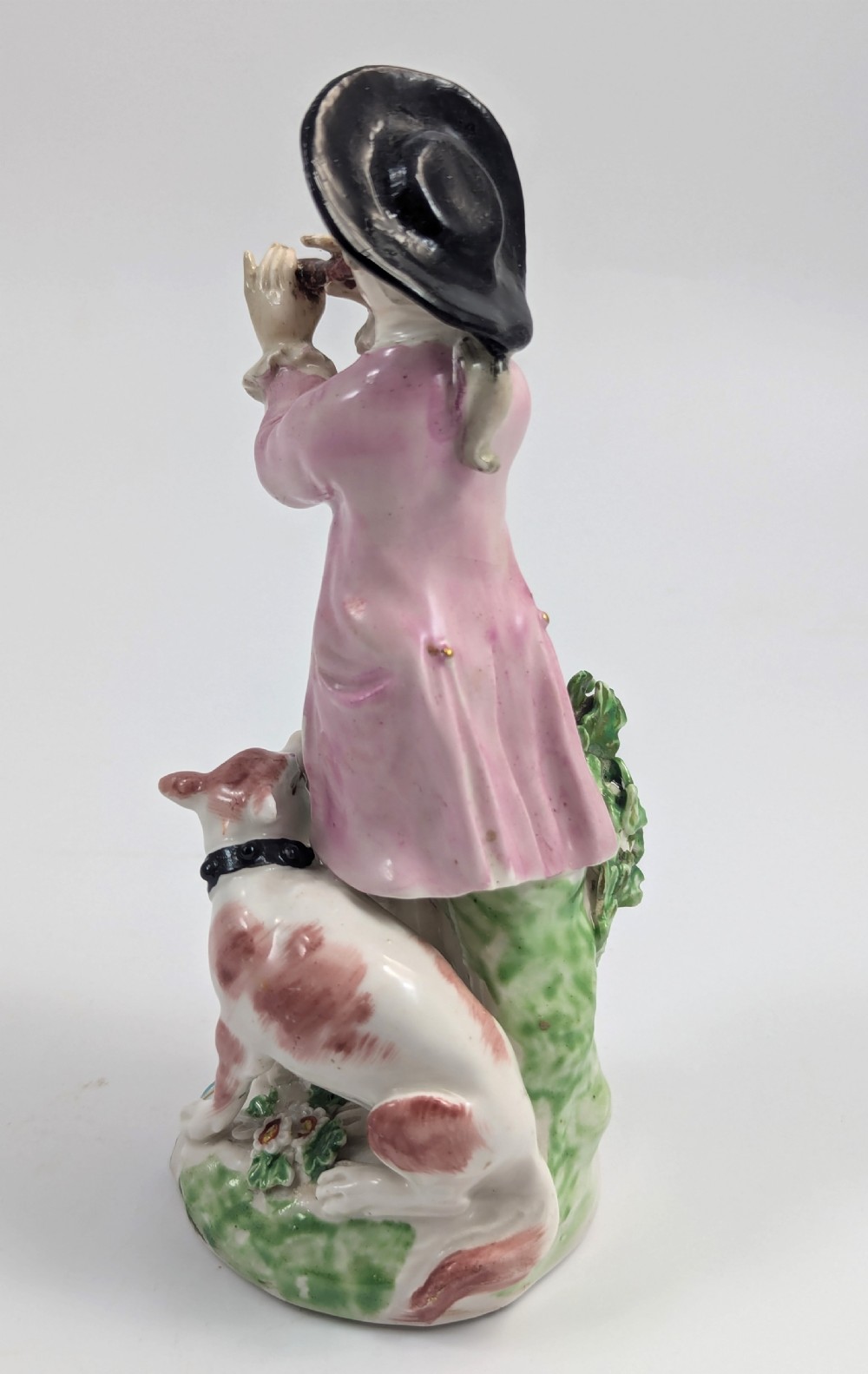 An 18th-century Derby soft-paste porcelain figurine depicting a shepherd playing a pipe with a dog standing beside him on a gilded scroll base. View IV