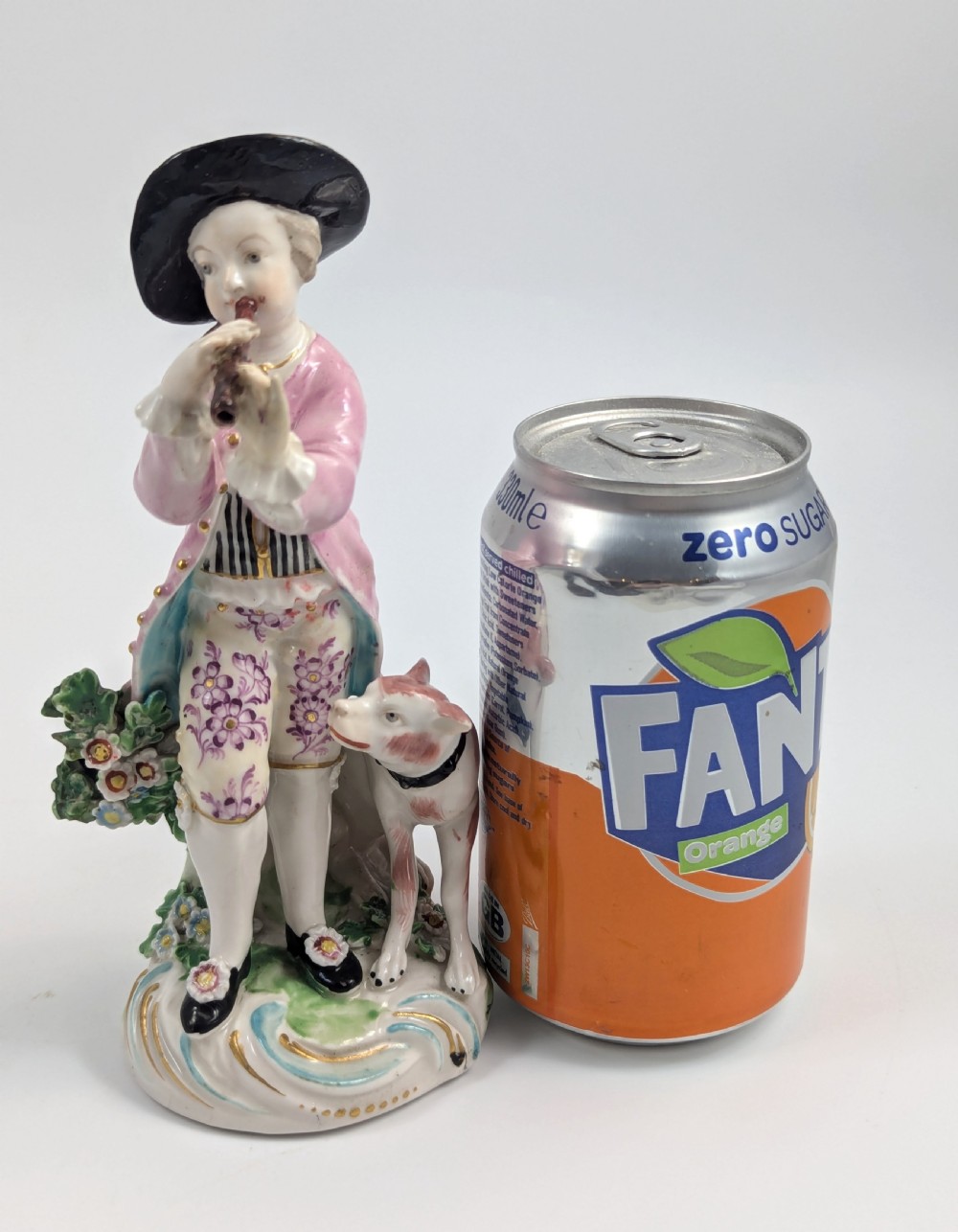 An 18th-century Derby soft-paste porcelain figurine depicting a shepherd playing a pipe with a dog standing beside him on a gilded scroll base. View IX