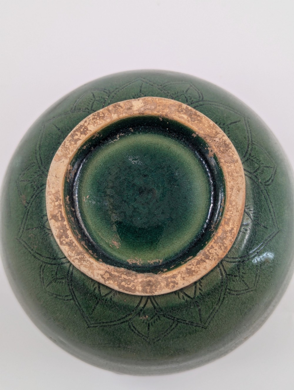 A rounded olive green celadon ceramic jar with four loop handles along the rim, featuring crackle glaze and incised line drawings of ducks and lotus plants. View VII