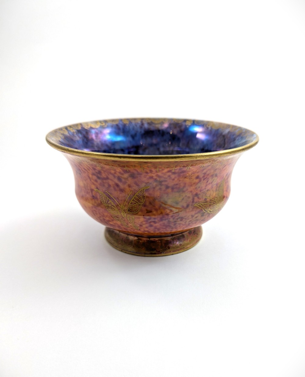 An antique Wedgwood ceramic bowl featuring a mottled orange and pink exterior with gilded butterfly motifs and an iridescent purple and blue interior glaze. View II