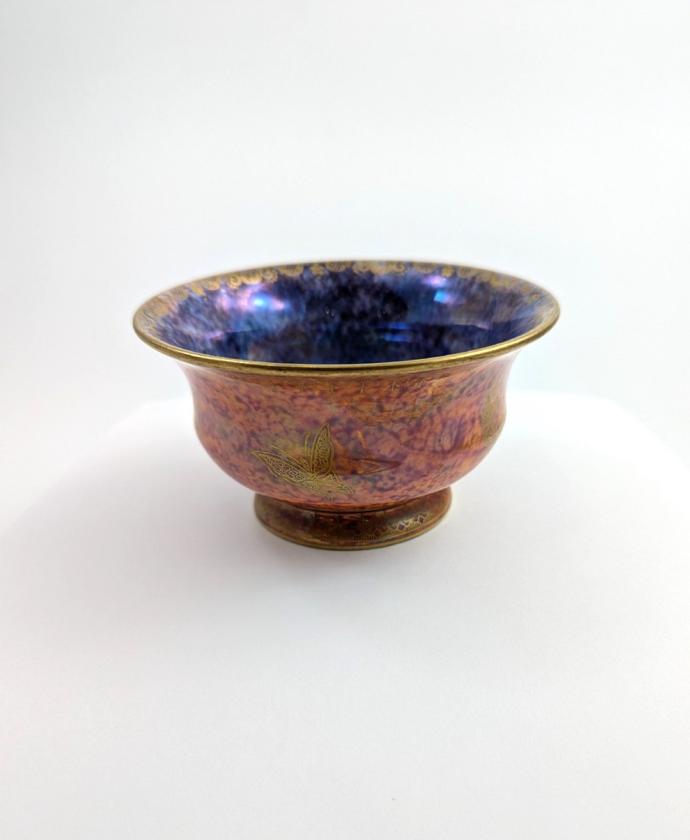 An antique Wedgwood ceramic bowl featuring a mottled orange and pink exterior with gilded butterfly motifs and an iridescent purple and blue interior glaze. View III