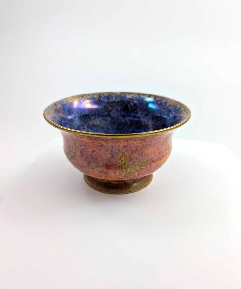 An antique Wedgwood ceramic bowl featuring a mottled orange and pink exterior with gilded butterfly motifs and an iridescent purple and blue interior glaze. View VI