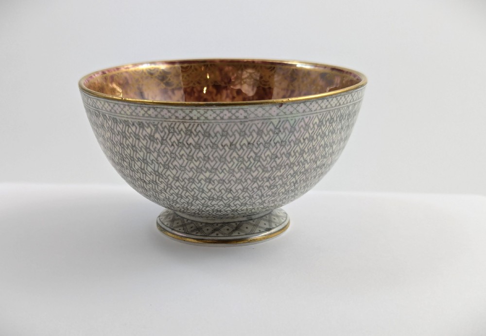 A small footed Wedgwood porcelain bowl featuring a grey diaper patterned exterior and a mottled orange lustre interior with gilt trim. View II
