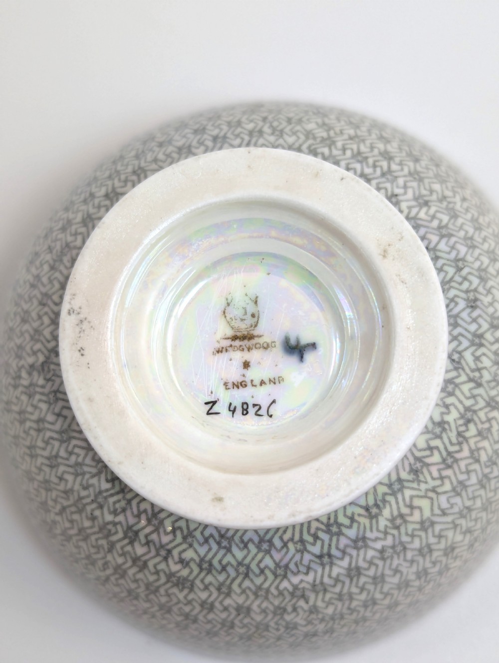 A small footed Wedgwood porcelain bowl featuring a grey diaper patterned exterior and a mottled orange lustre interior with gilt trim. View VI