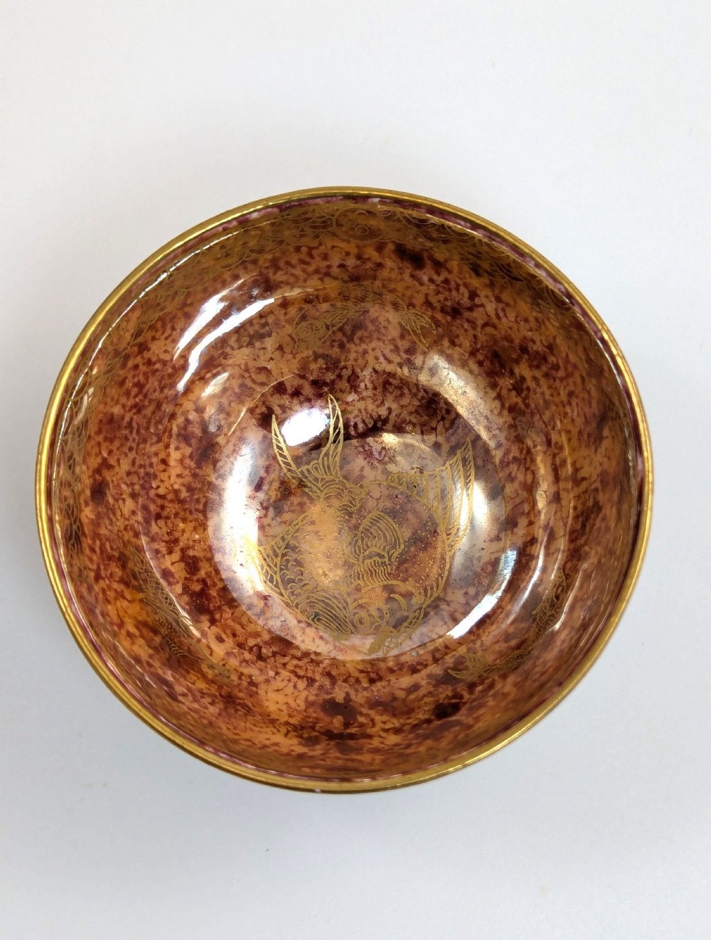 A small footed Wedgwood porcelain bowl featuring a grey diaper patterned exterior and a mottled orange lustre interior with gilt trim. View VII