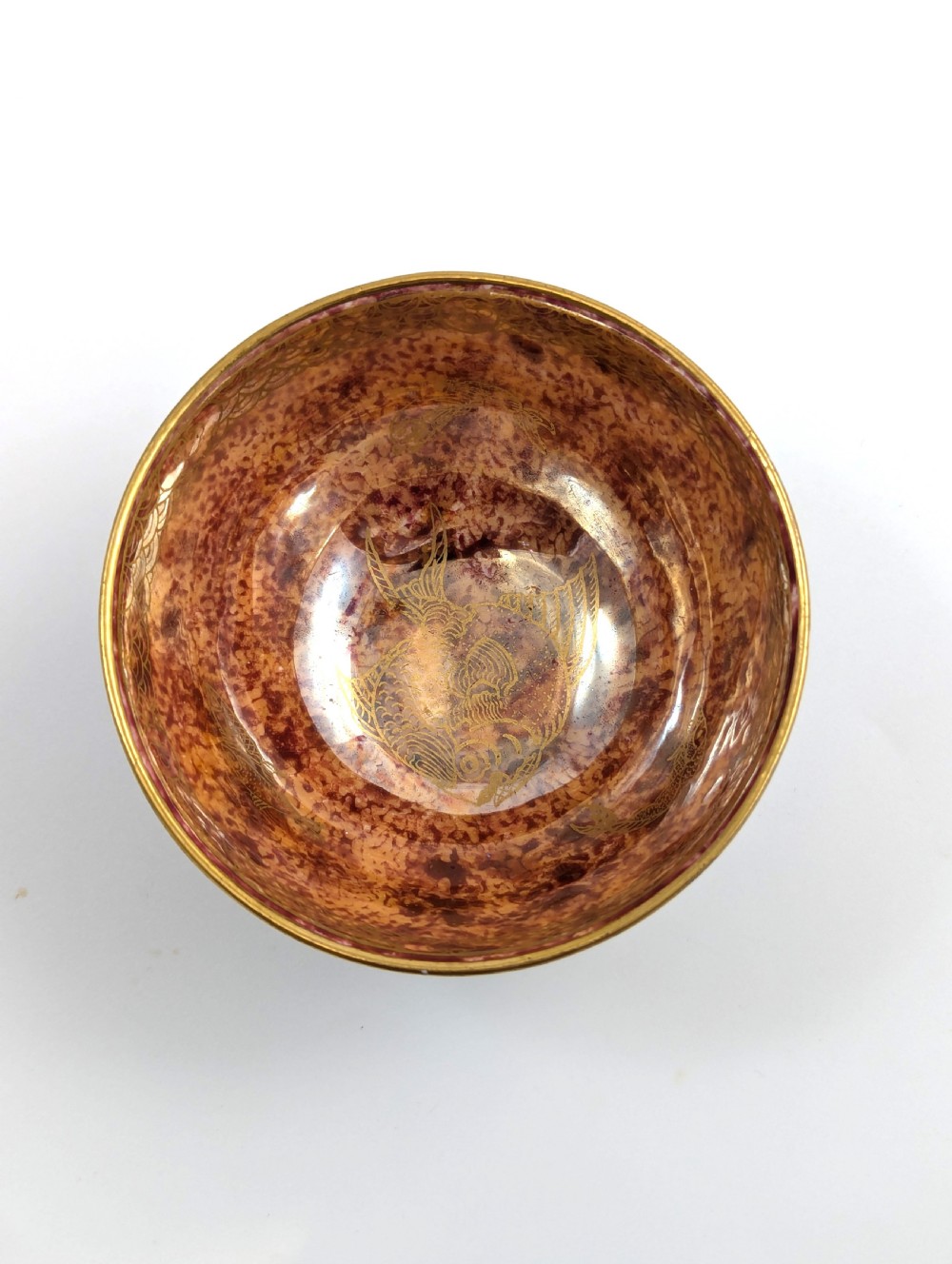 A small footed Wedgwood porcelain bowl featuring a grey diaper patterned exterior and a mottled orange lustre interior with gilt trim. View VIII