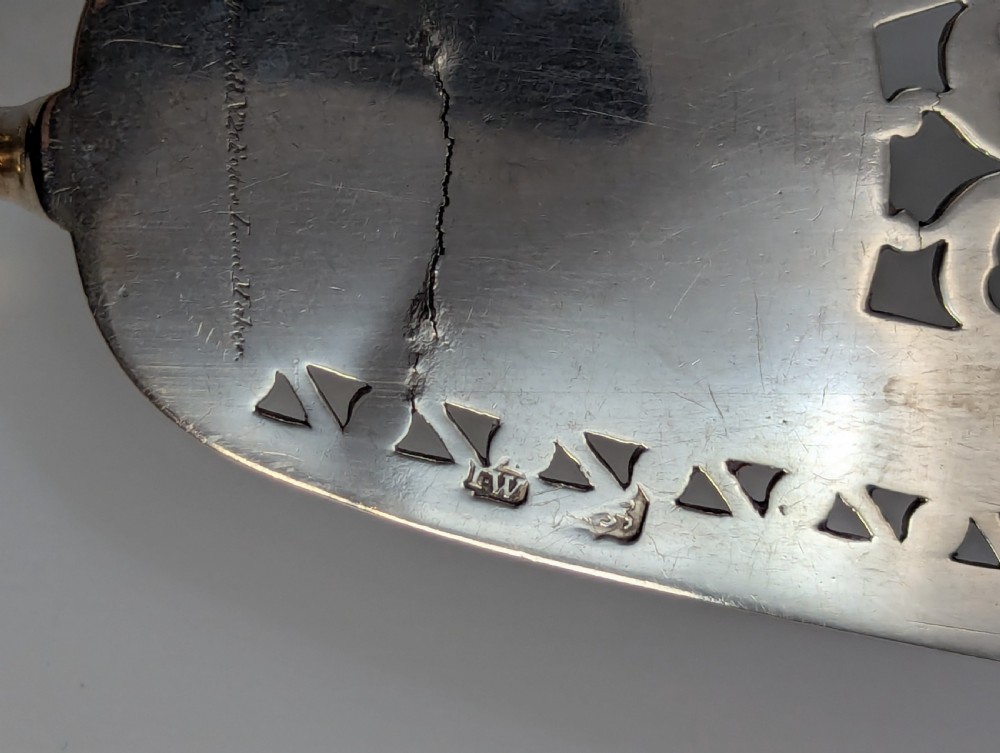An antique George III sterling silver fish slice featuring an intricately pierced and engraved blade with a tapered handle. View IV
