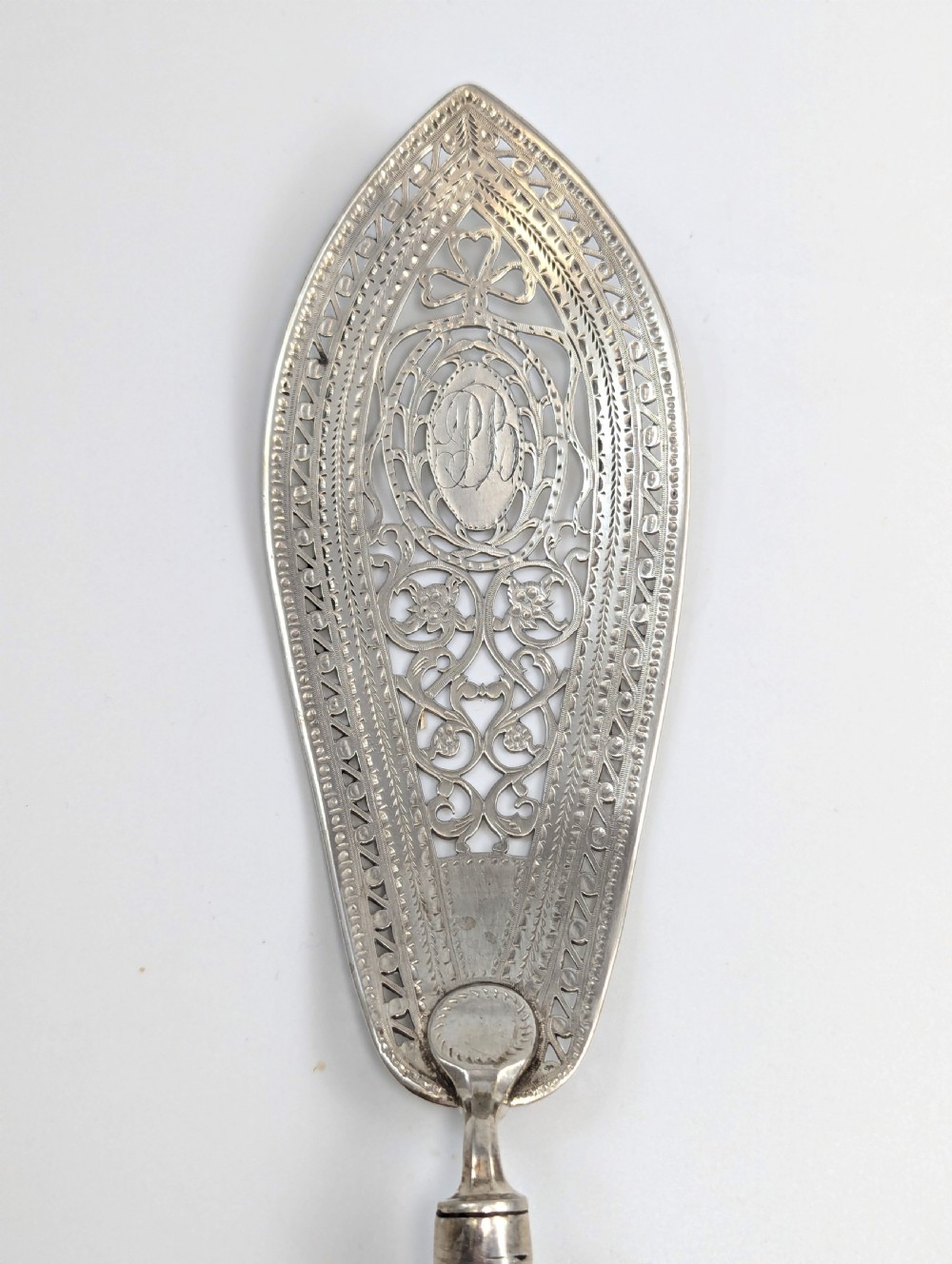 An antique George III sterling silver fish slice featuring an intricately pierced and engraved blade with a tapered handle. View VI