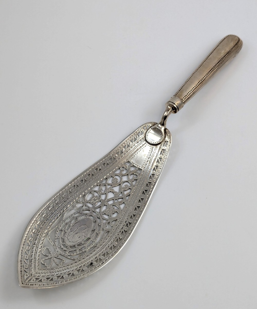 An antique George III sterling silver fish slice featuring an intricately pierced and engraved blade with a tapered handle. View VIII