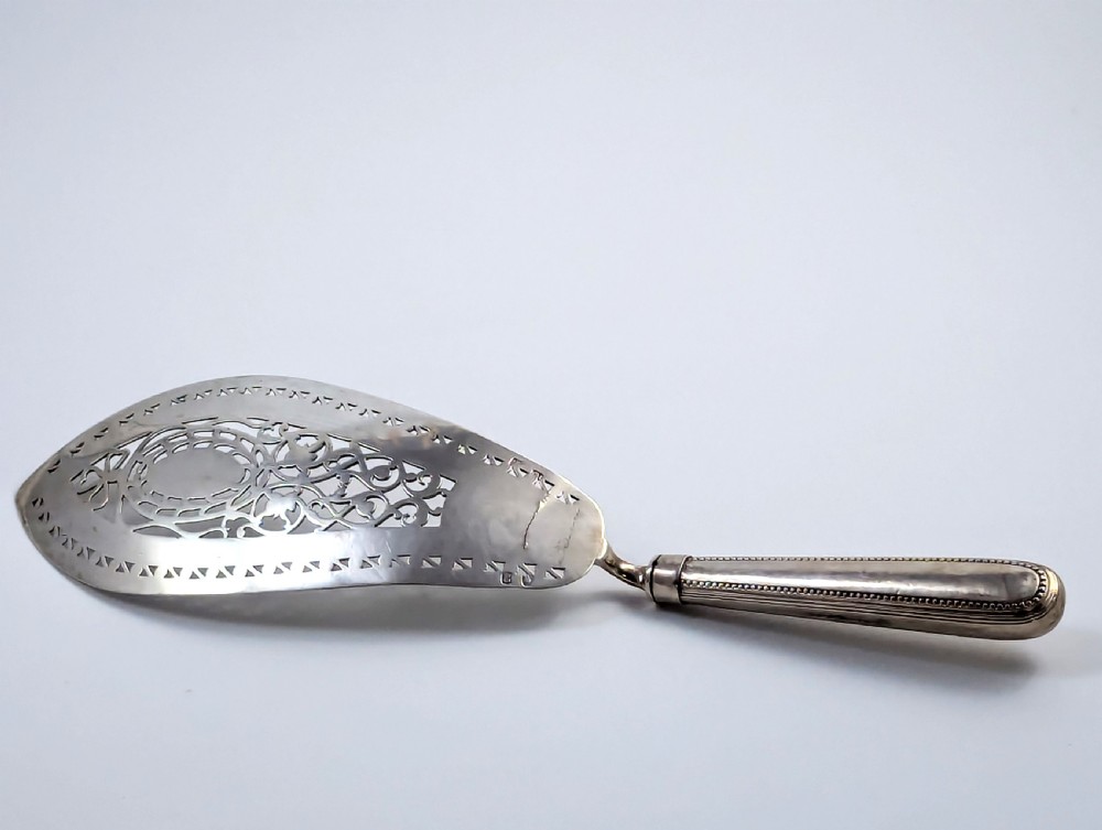 An antique George III sterling silver fish slice featuring an intricately pierced and engraved blade with a tapered handle. View XI