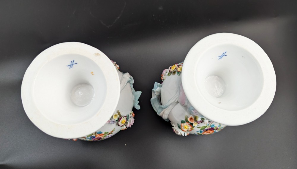 A pair of antique Sitzendorf hard-paste white porcelain potpourri vases decorated with encrusted hand-moulded flowers, scrolling handles, pierced lids, and painted floral sprays. View XII
