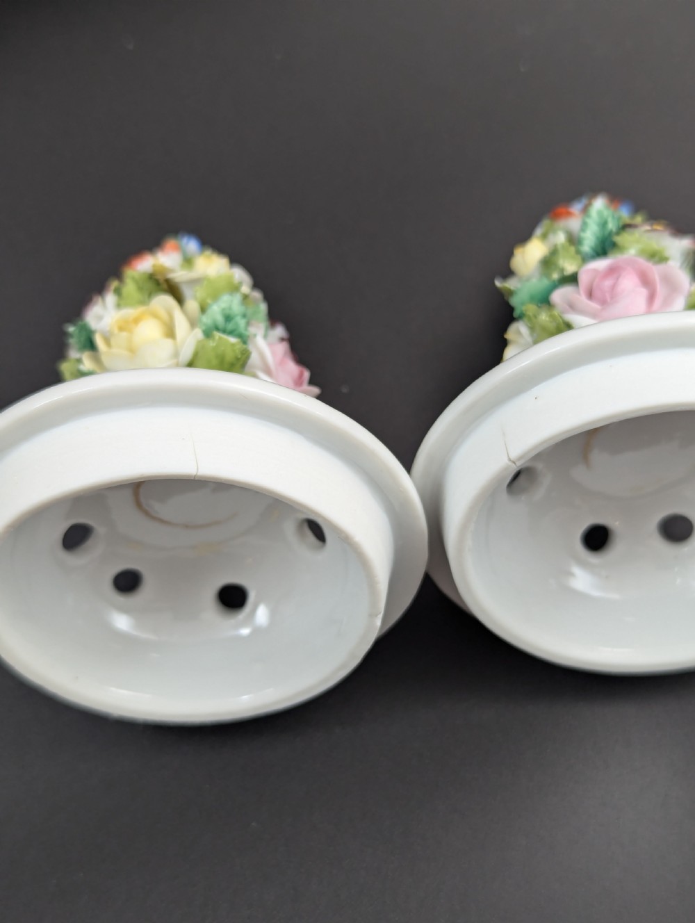 A pair of antique Sitzendorf hard-paste white porcelain potpourri vases decorated with encrusted hand-moulded flowers, scrolling handles, pierced lids, and painted floral sprays. View XVI