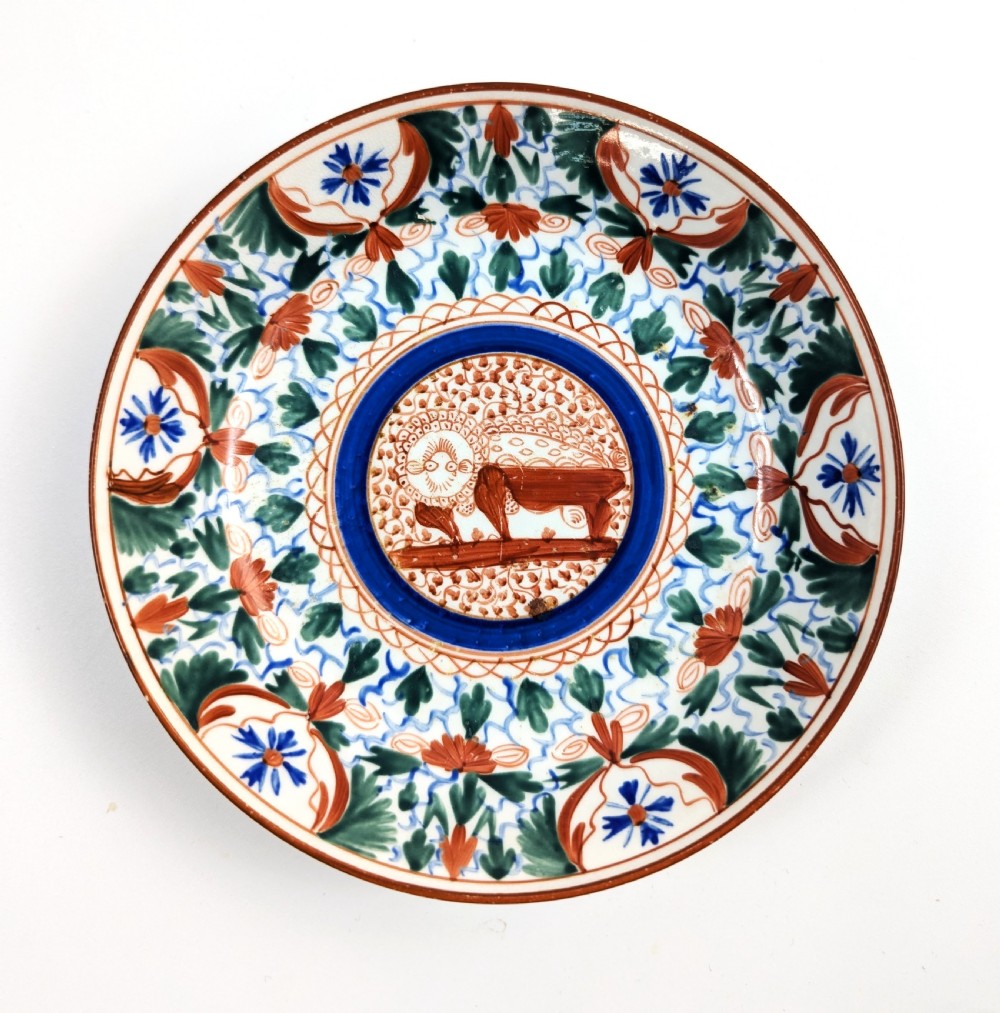 An early nineteenth-century Minton porcelain trio comprising a coffee can, saucer, and plate decorated with hand-painted terracotta, blue, and green floral and animal motifs. View V