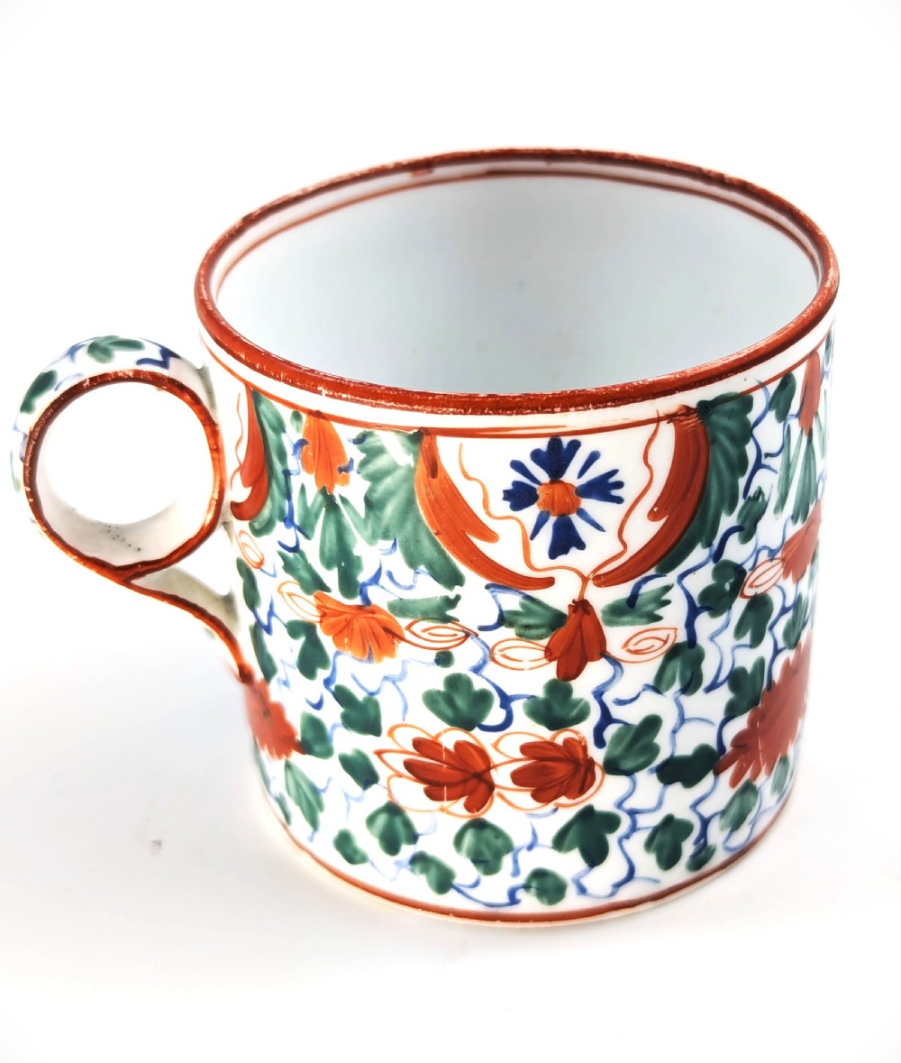 An early nineteenth-century Minton porcelain trio comprising a coffee can, saucer, and plate decorated with hand-painted terracotta, blue, and green floral and animal motifs. View IX