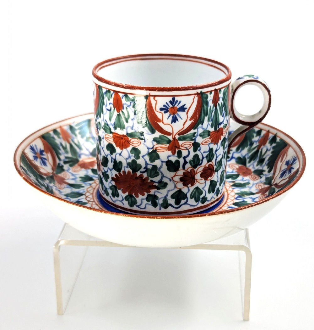 An early nineteenth-century Minton porcelain trio comprising a coffee can, saucer, and plate decorated with hand-painted terracotta, blue, and green floral and animal motifs. View XIII