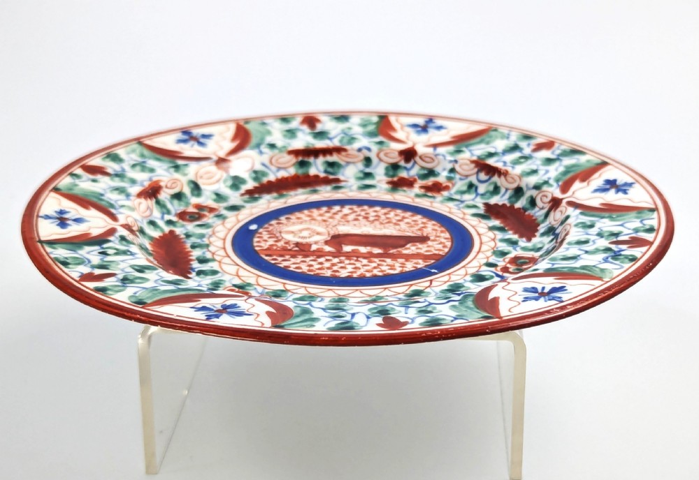 An early nineteenth-century Minton porcelain trio comprising a coffee can, saucer, and plate decorated with hand-painted terracotta, blue, and green floral and animal motifs. View XIV