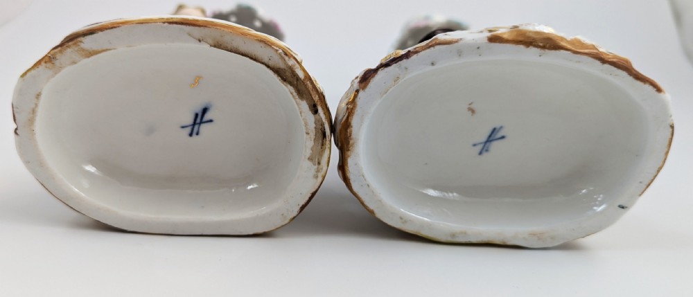 A pair of hand-painted German Sitzendorf porcelain figural candlesticks featuring a shepherdess and a lute player seated beside tree trunks supporting leafy sconces. View VI