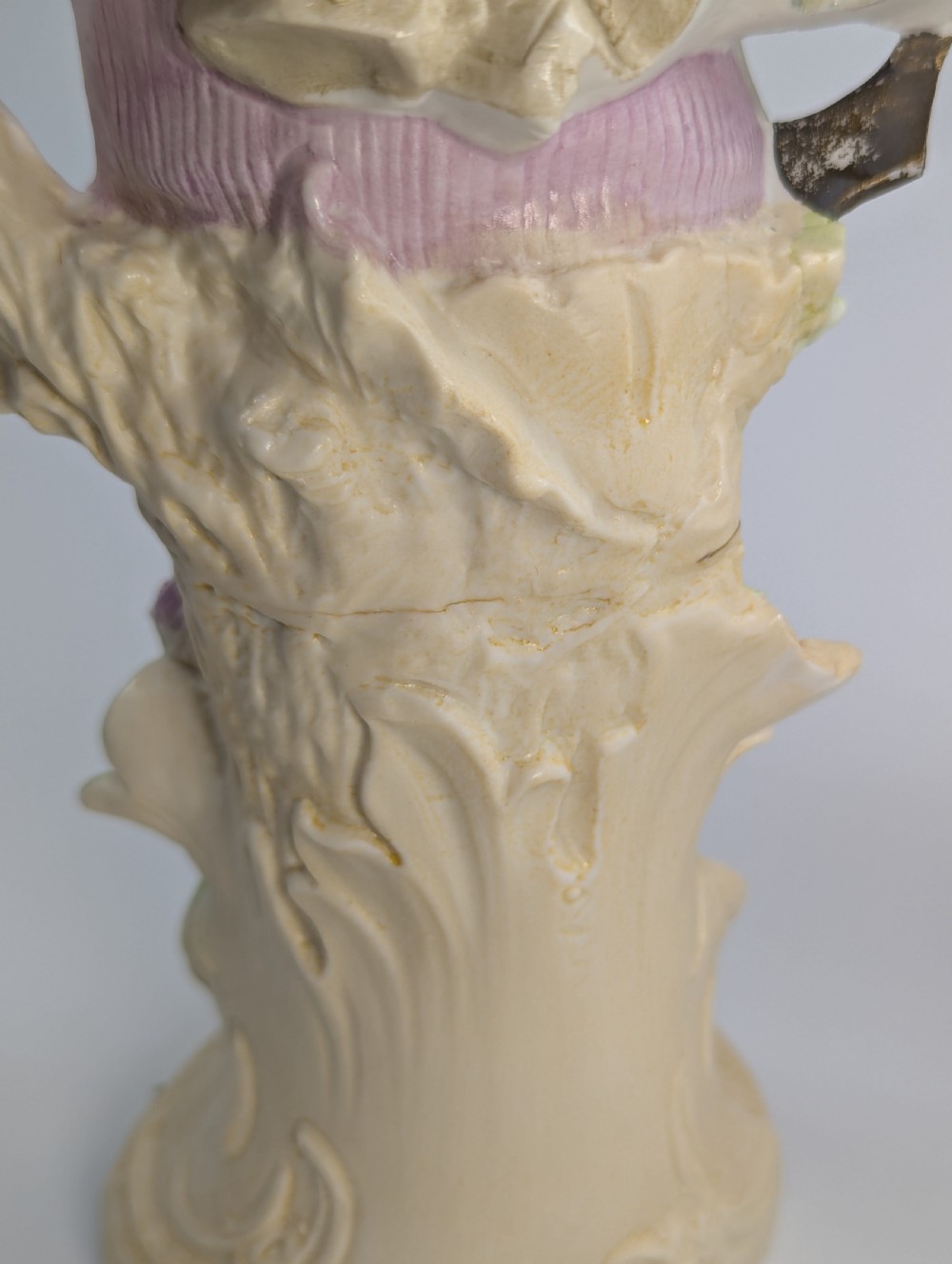 A pair of antique German bisque porcelain figurines depicting a man and woman in detailed pastoral attire with gilded accents on scroll bases. View XI